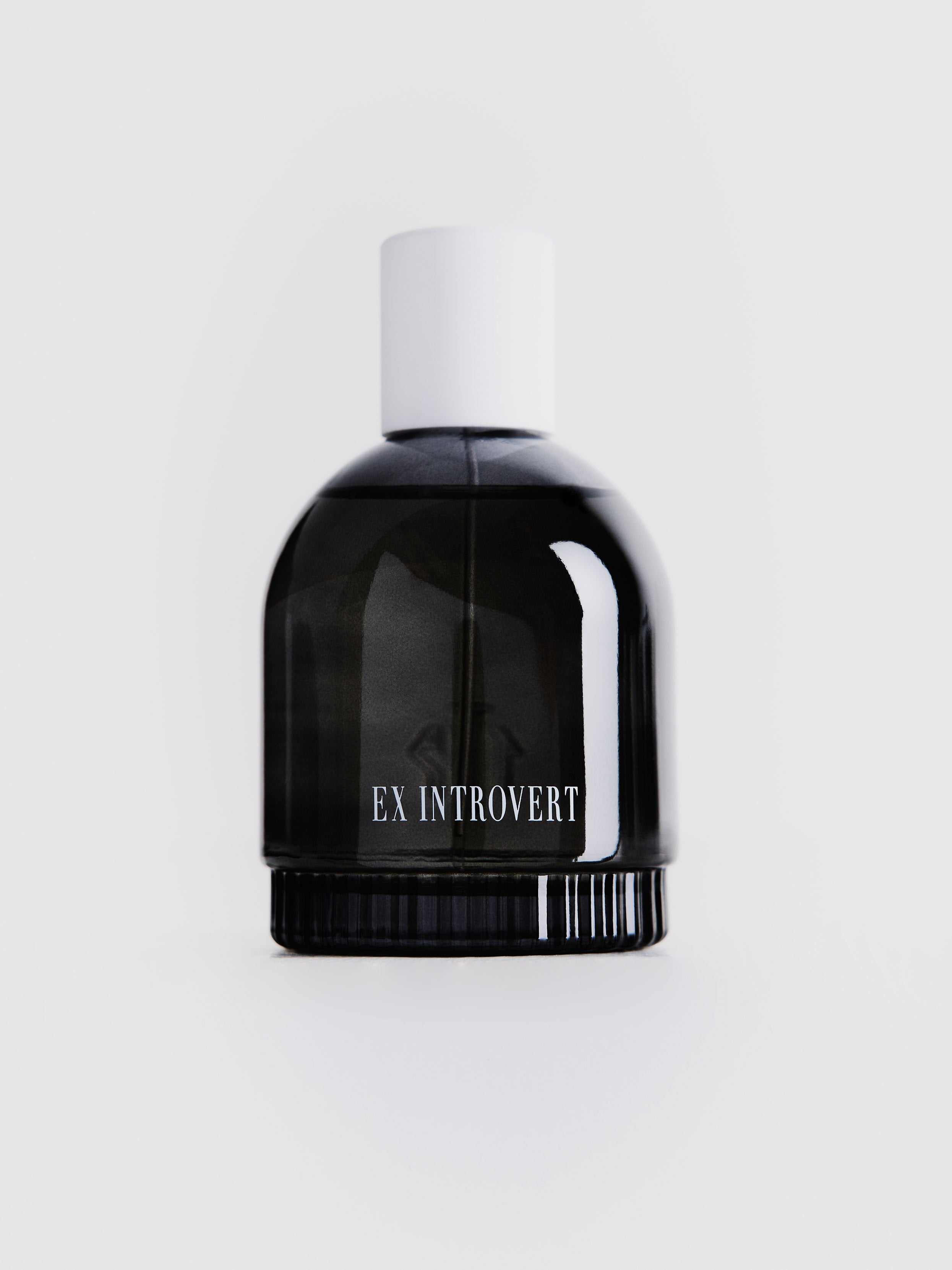 Strong dark gray transparent perfume bottle with "EX INTROVERT" label in the center, with white cap on top