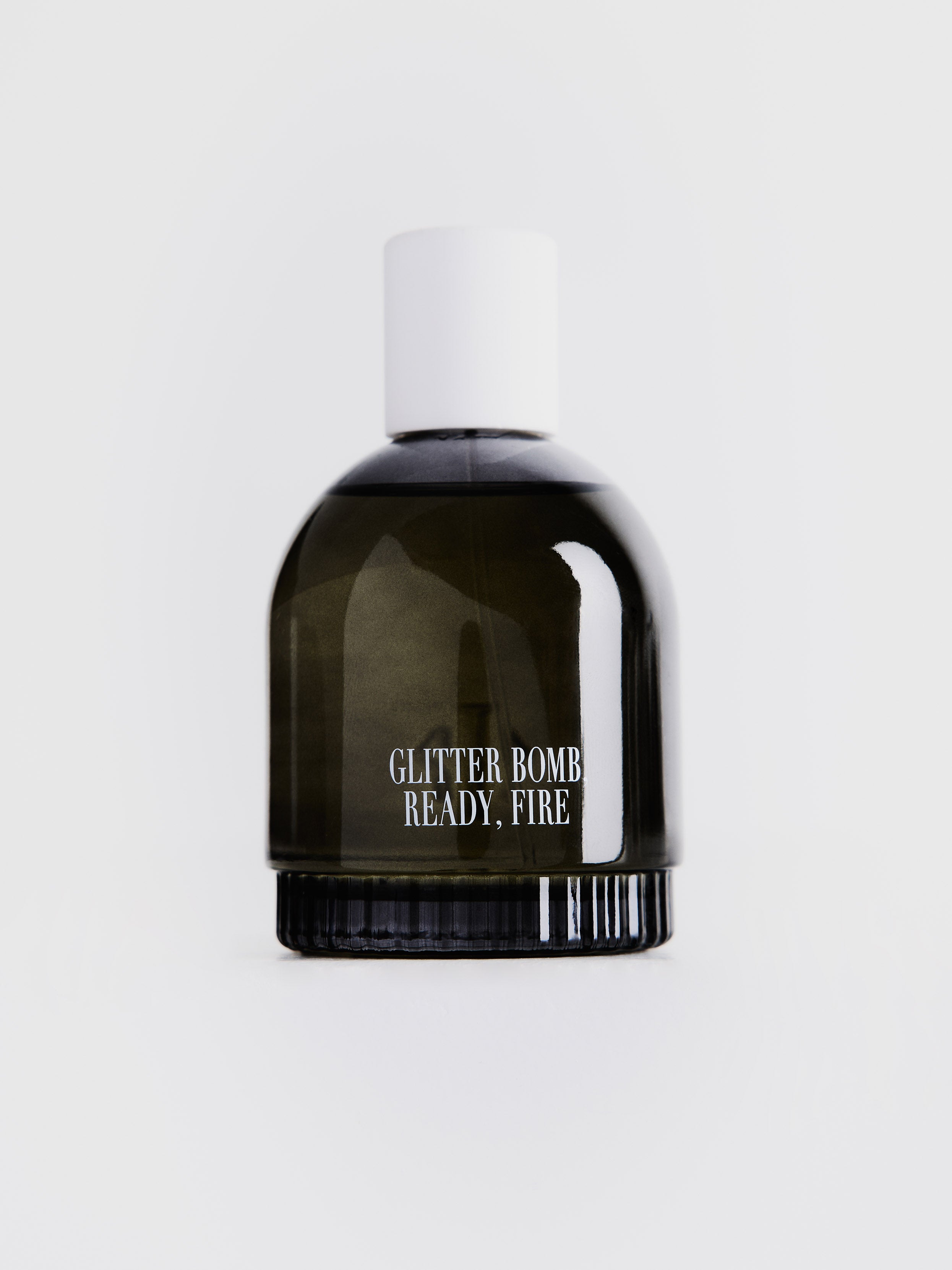 Black glitter bomb bottle with white cap on a light gray background