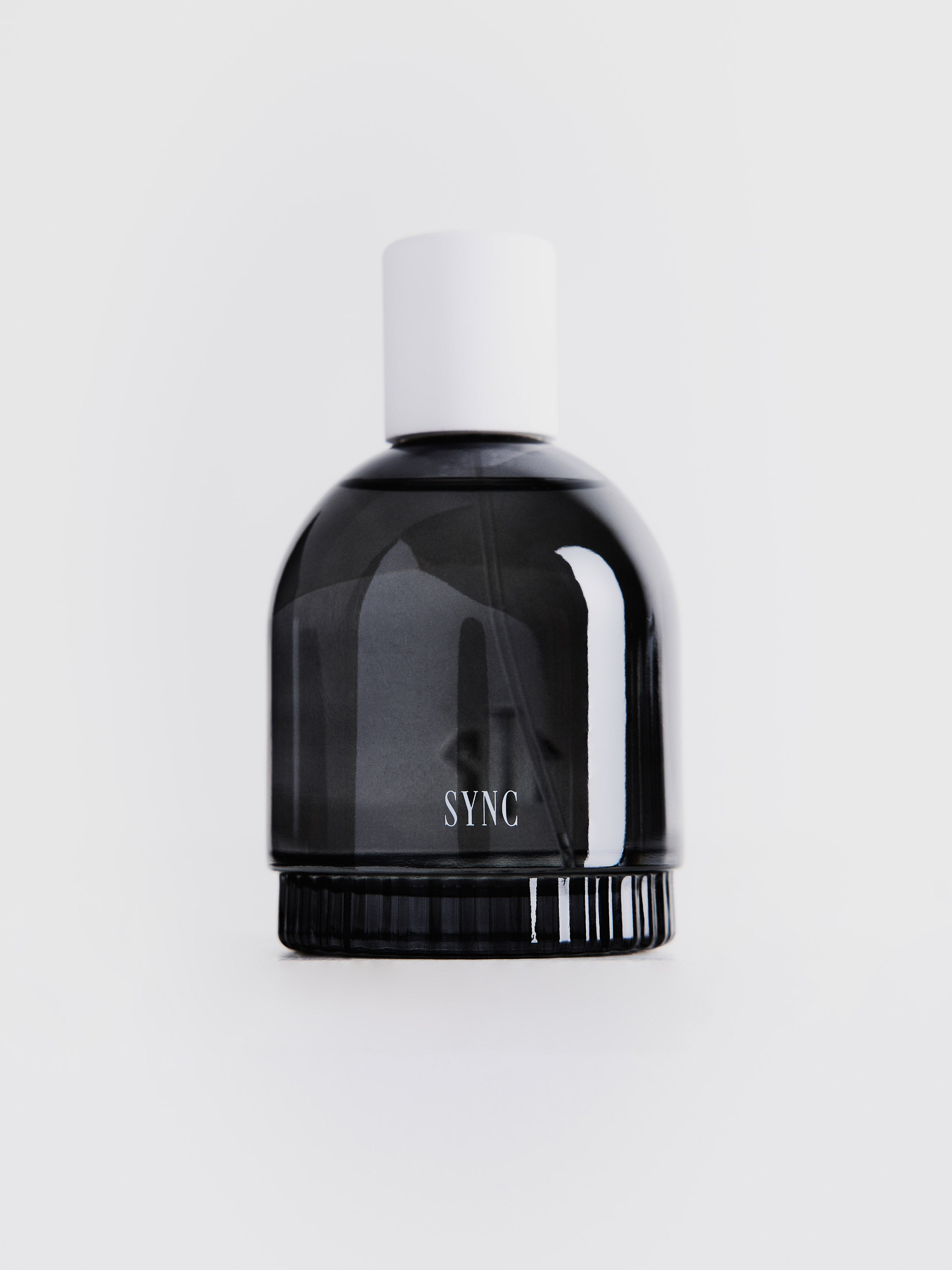 Black bottle with white cap labeled 'SYNC' on a light gray background